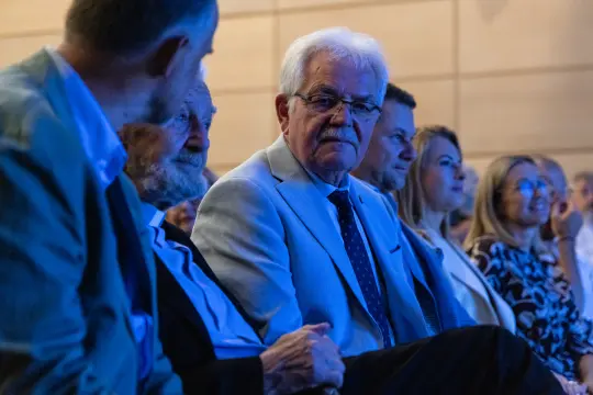Grupa osób siedzących na widowni podczas wydarzenia.