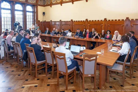 Spotkanie w sali konferencyjnej z uczestnikami przy stole.