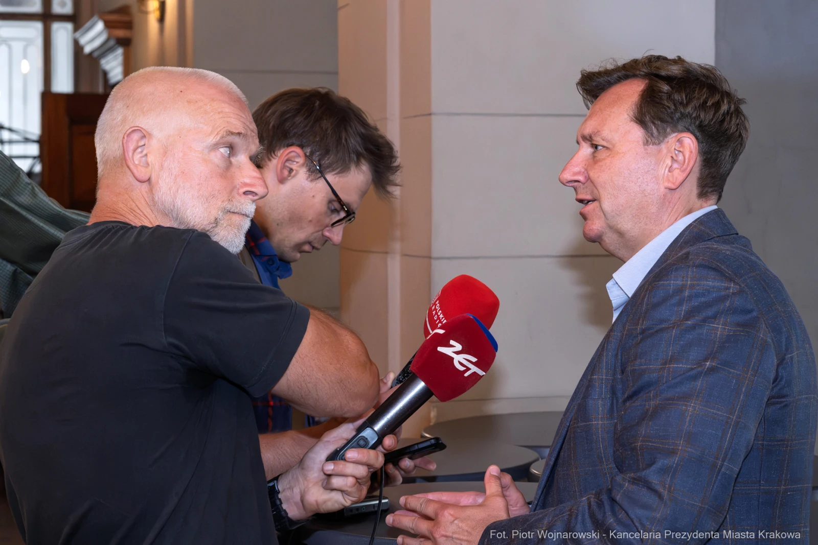 Mężczyzna udziela wywiadu, obok dwóch innych mężczyzn z kamerą i telefonem.  Autor: Piotr Wojnarowski