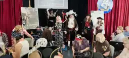 Grupa osób w strojach piratów oraz uczestnicy wydarzenia w sali z dekoracjami tematycznymi.