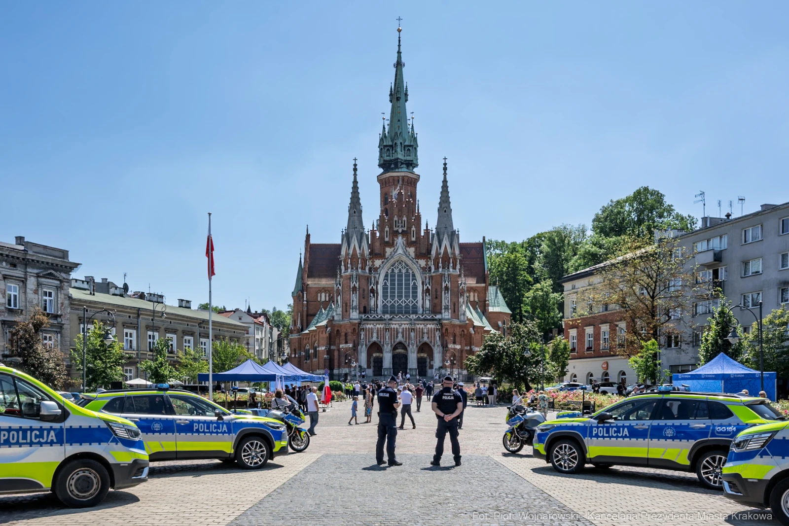Krakowska architektura z kościołem i radiowozami policji na placu.  Autor: Piotr Wojnarowski