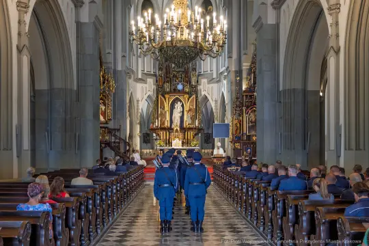 Ceremonia w kościele z uczestnikami i żołnierzami w mundurach.
