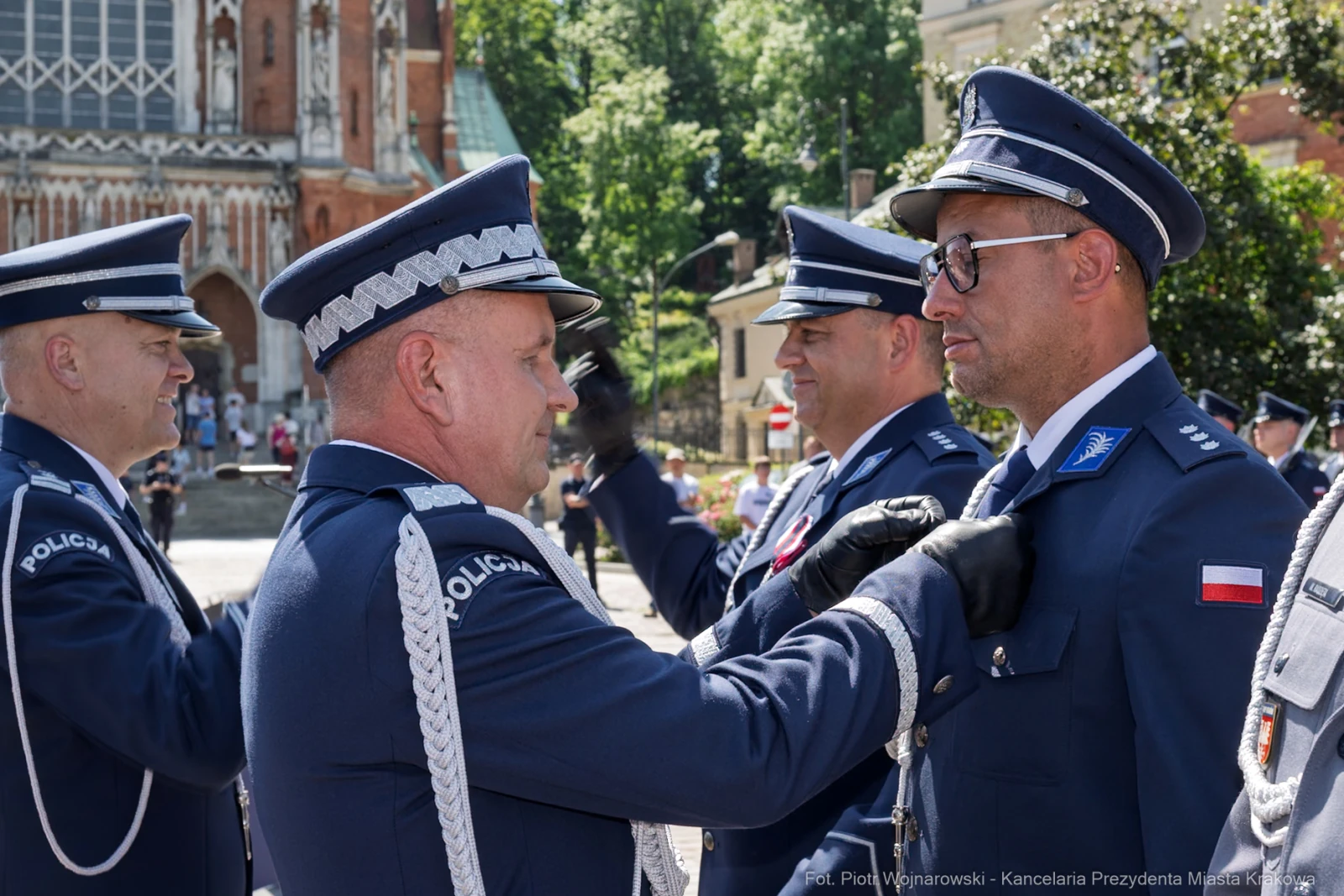 Ceremonia wręczenia odznaczeń policjantom w mundurach na tle budynku.  Autor: Piotr Wojnarowski