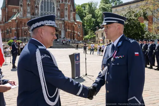 Ceremonia wręczenia odznaczeń w obecności policji i przedstawicieli władz.
