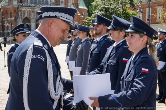 Ceremonia wręczenia odznaczeń policjantom w mundurach na tle budynku.