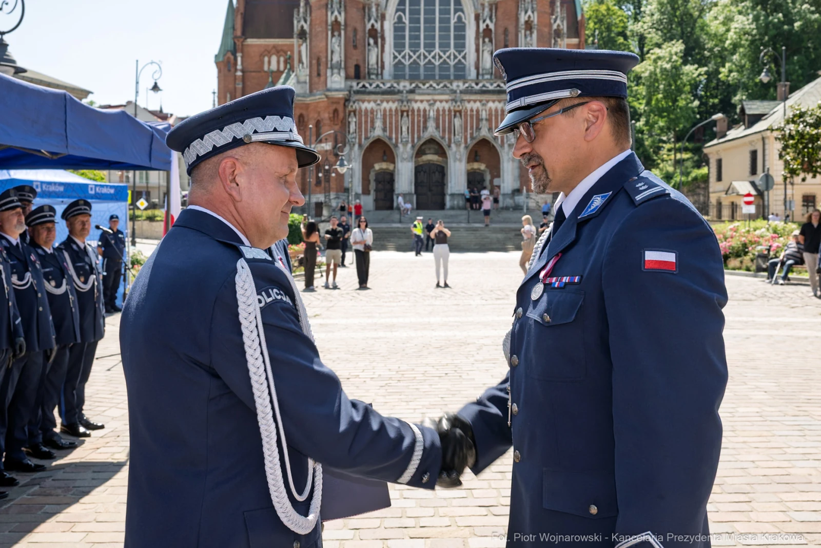 Ceremonia wręczenia odznaczeń w tle katedry, dwóch mężczyzn w mundurach w uścisku dłoni.  Autor: Piotr Wojnarowski