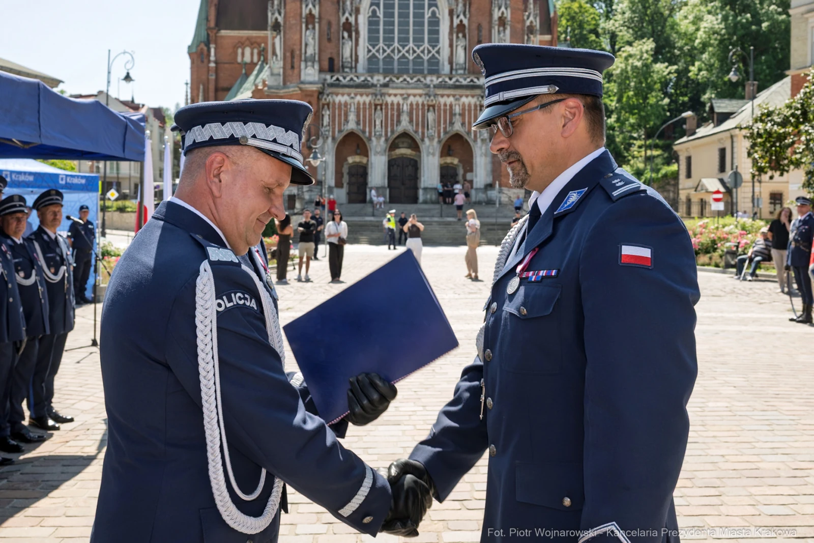 Dwaj policjanci w mundurach wymieniają uściski dłoni podczas ceremonii.  Autor: Piotr Wojnarowski