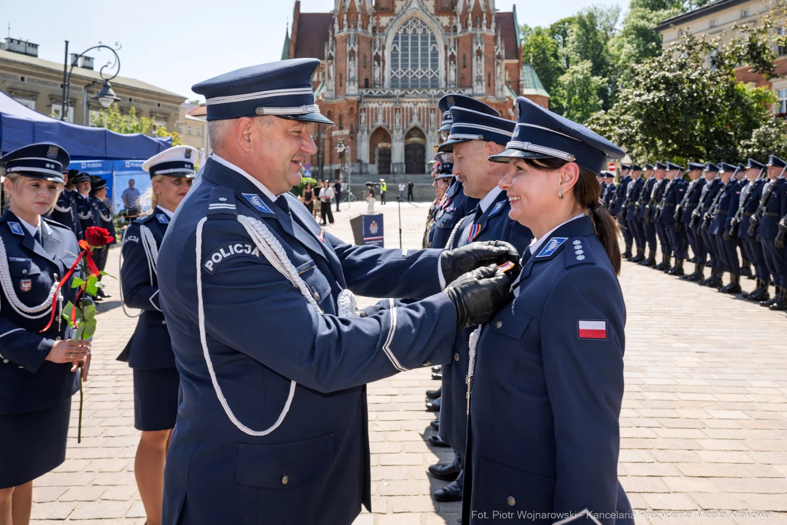 Ceremonia wręczenia odznaczeń policjantom na tle zabytkowego budynku.  Autor: Piotr Wojnarowski