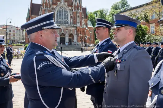Ceremonia wręczenia odznaczeń policjantom w tle katedra.