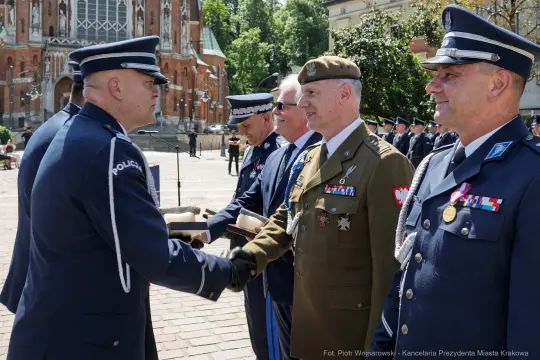 Ceremonia wręczenia odznaczeń w Krakowie, uczestnicy w mundurach wojskowych i policyjnych.