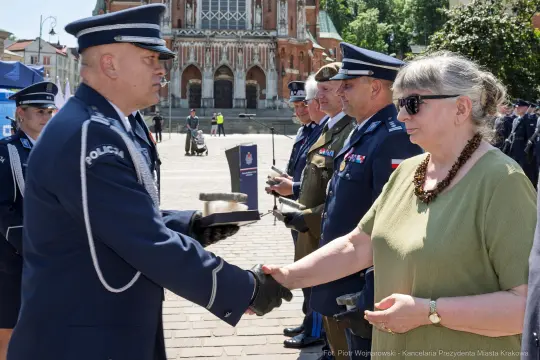 Ceremonia wręczenia odznaczeń, mężczyzna w mundurze podaje rękę kobiecie.