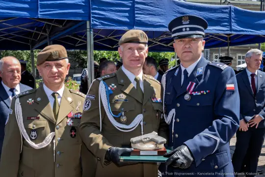 Dwaj oficerowie wojskowi wręczają sobie nagrodę podczas ceremonii.