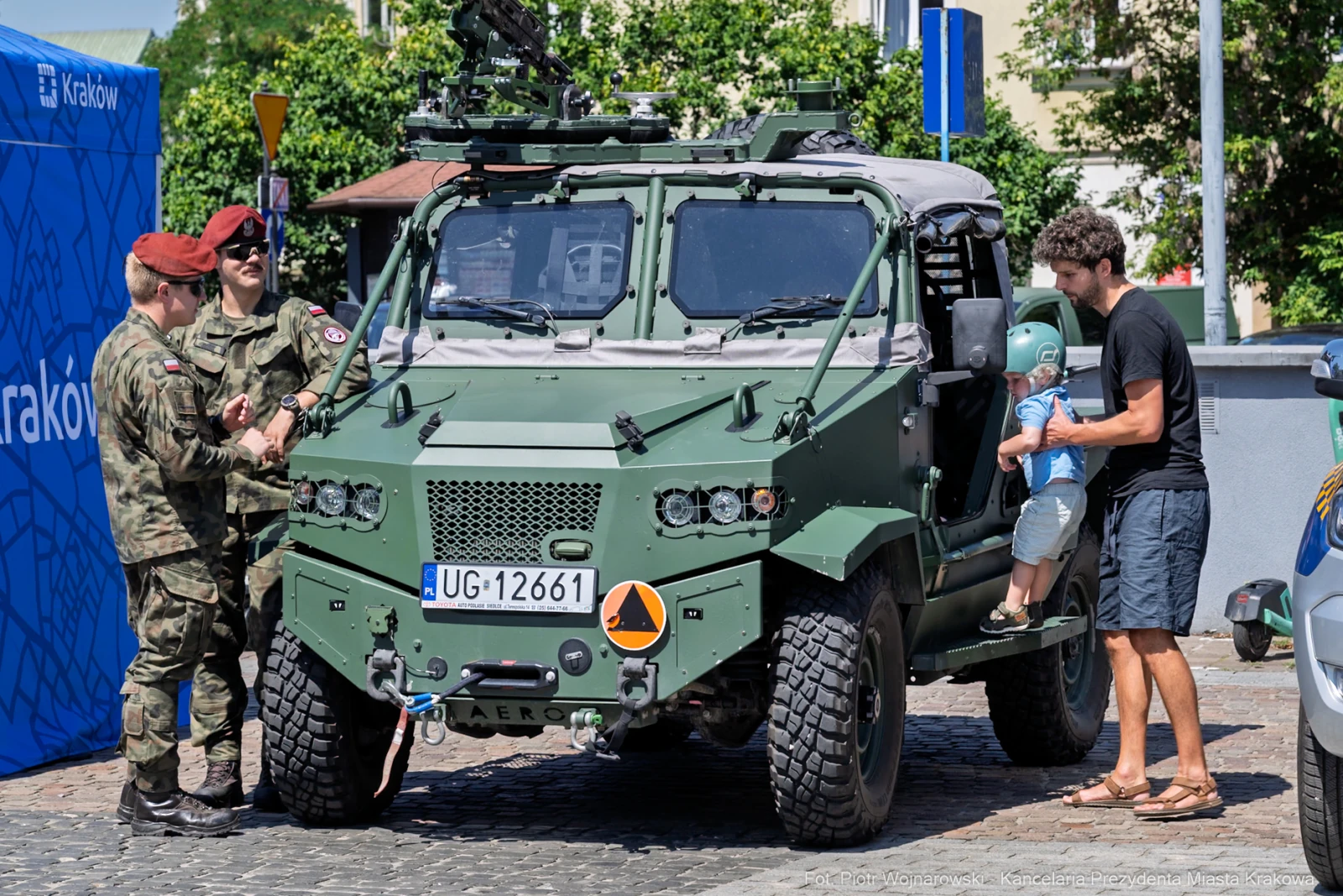Wojsko przy wojskowym pojeździe, mężczyzna z dzieckiem obok.  Autor: Piotr Wojnarowski