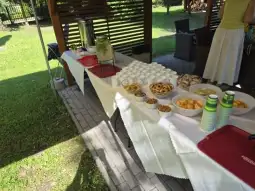 Stół z przekąskami, napojami i deserami na świeżym powietrzu.