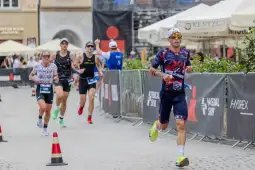 Biegacze uczestniczą w zawodach triathlonowych na miejskiej trasie.