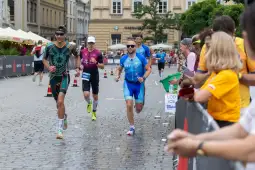 Biegacze uczestniczący w zawodach triathlonowych na ulicach miasta.