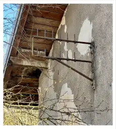 Stara antena zamontowana na ścianie budynku z od peelingującą się farbą.