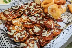 Placki ziemniaczane z sosem i pączki na talerzu.