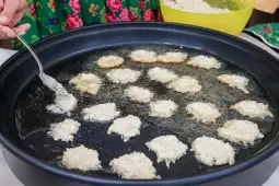 Smażenie placków na głębokim oleju w dużym garnku.