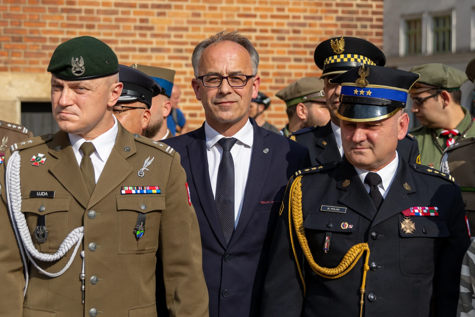 Trzech mężczyzn w mundurach wojskowych i policyjnych, stojących obok siebie.  Autor: Bogusław Świerzowski