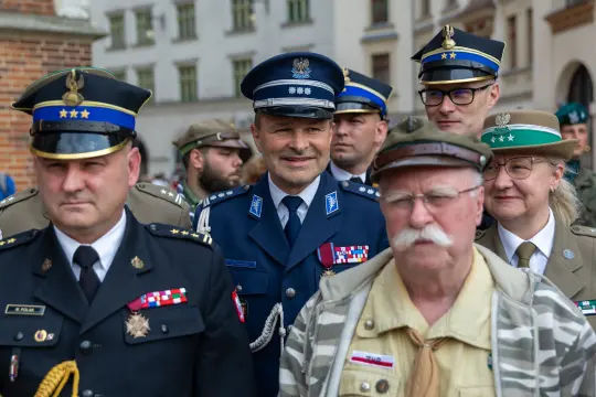 Grupa mężczyzn i kobiet w mundurach wojskowych i policyjnych, z odznaczeniami, podczas uroczystości.