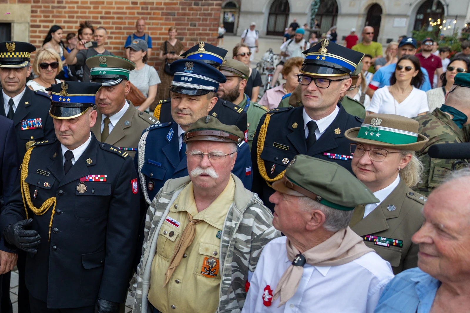 Grupa mężczyzn i kobiet w mundurach wojskowych i policyjnych, uczestniczących w wydarzeniu publicznym.  Autor: Bogusław Świerzowski