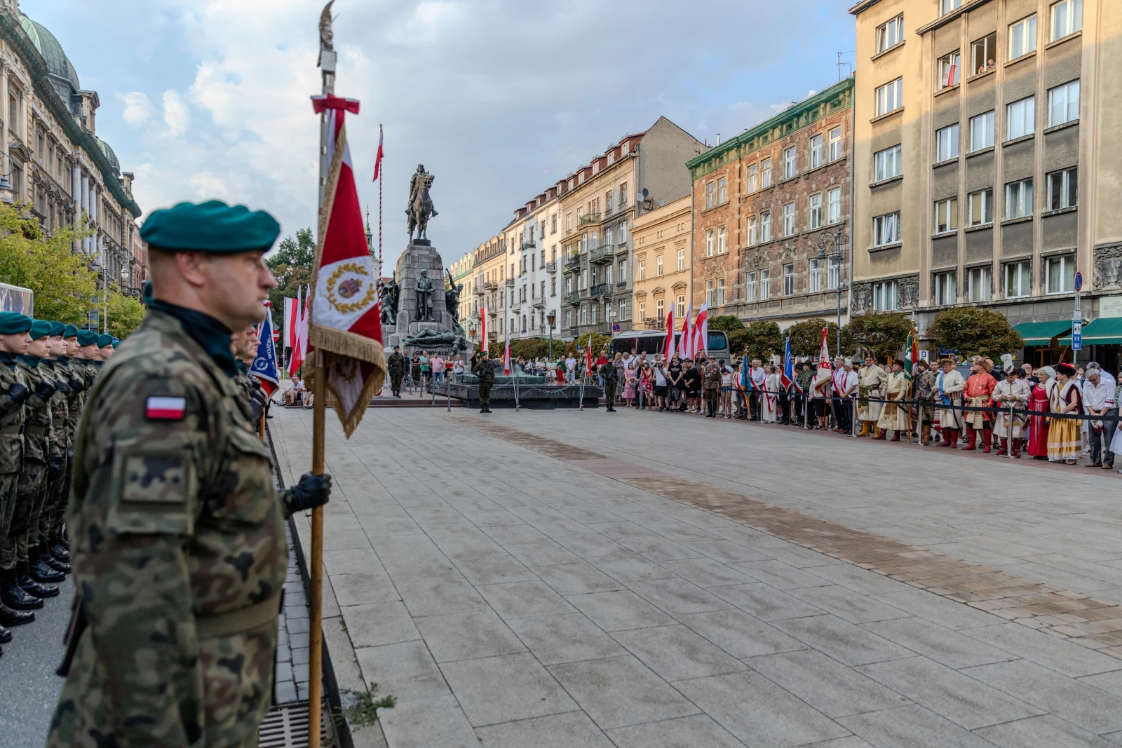 Ceremonia z udziałem żołnierzy, flagi i tłum ludzi na ulicy.  Autor: Bogusław Świerzowski