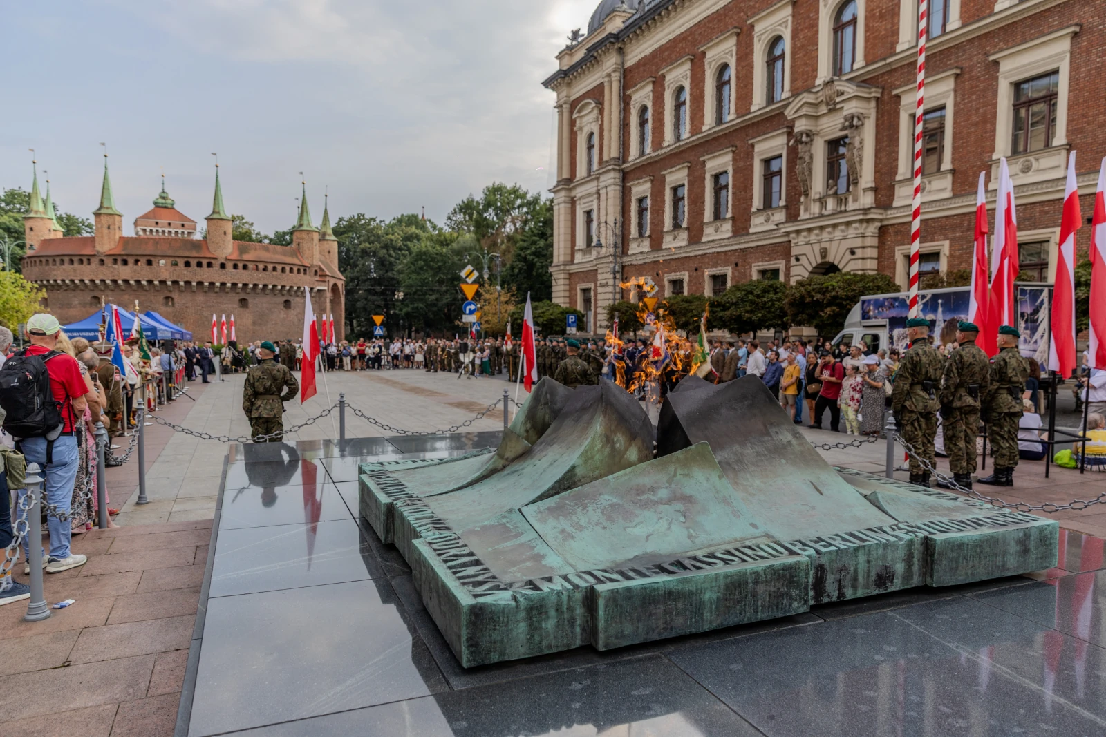 Pomnik z wiecznym ogniem, tłum ludzi, flagi, zamek w tle.  Autor: Bogusław Świerzowski
