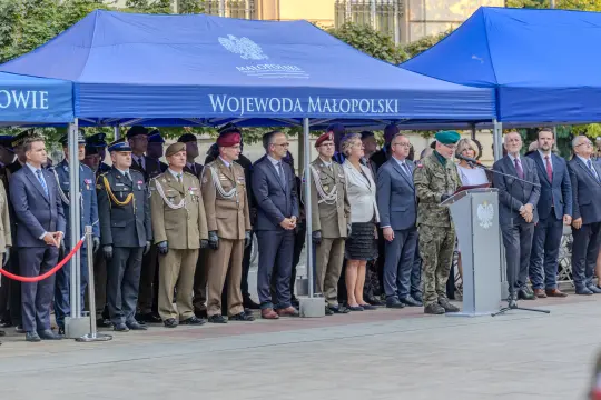 Uroczystość z udziałem wojskowych i przedstawicieli władz pod namiotami z logo Małopolski.