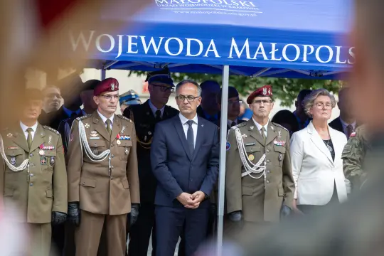 Uroczystość z udziałem wojskowych i cywilnych przedstawicieli pod namiotem.