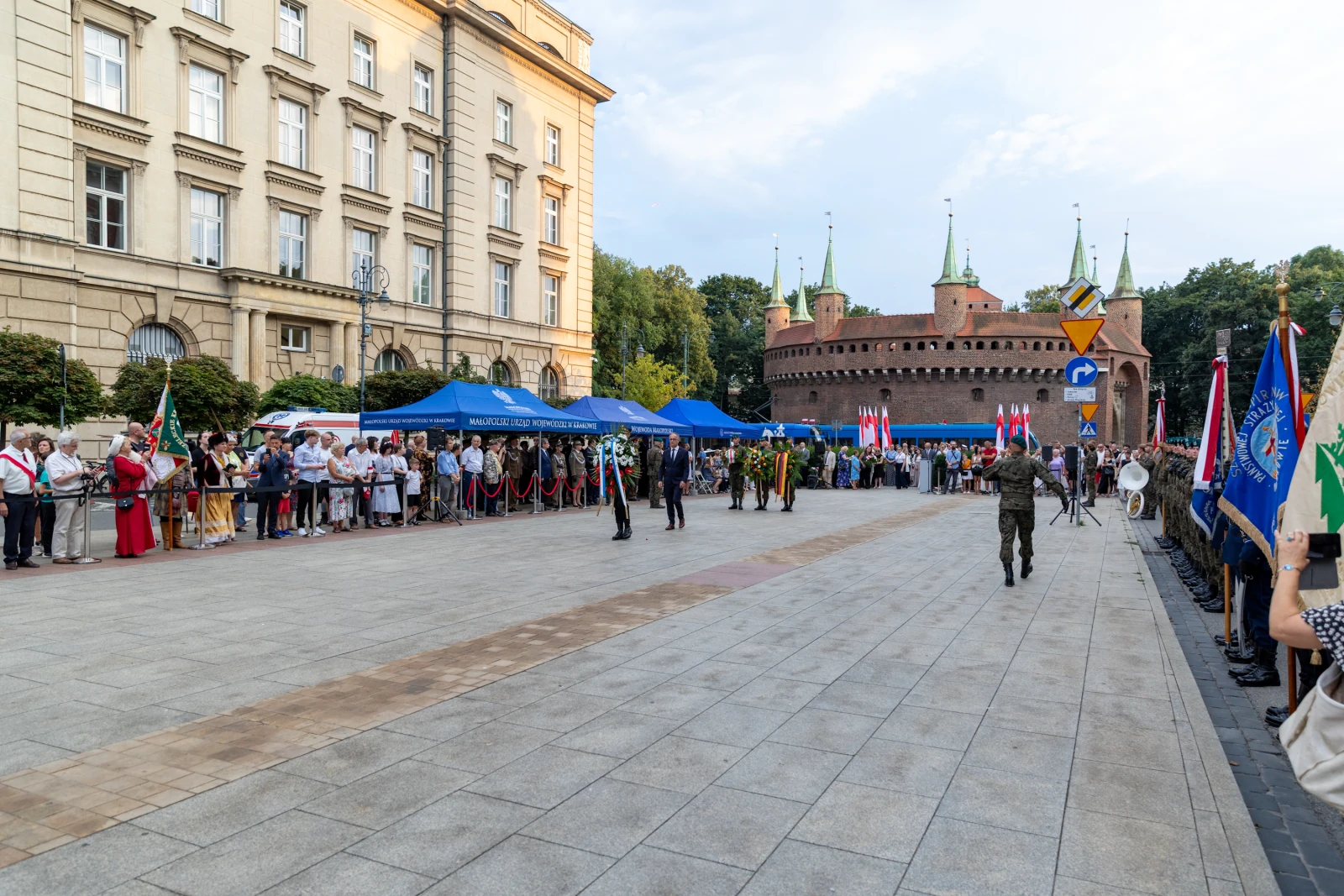 Ceremonia z udziałem żołnierzy, flagi i tłum ludzi przed zamkiem.  Autor: Bogusław Świerzowski