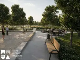 Nowoczesny park z alejkami, ławkami i ludźmi spędzającymi czas na świeżym powietrzu.