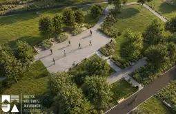 Park z alejkami, drzewami i ludźmi spacerującymi po ścieżkach.