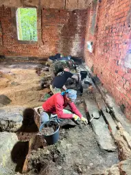 Archeolodzy prowadzą prace wykopaliskowe w ruinach budynku.