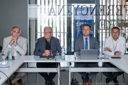 Czterech mężczyzn siedzących przy stole w sali konferencyjnej.