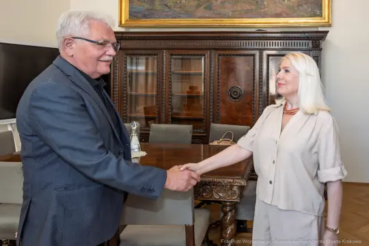 Mężczyzna i kobieta uściski dłoni w eleganckim wnętrzu.
