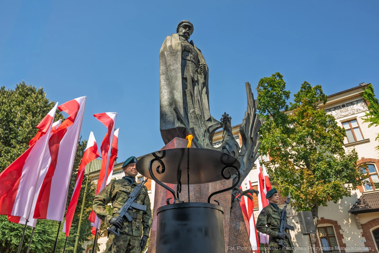 Pomnik z żołnierzem, flagi Polski w tle, uroczystość patriotyczna.  Autor: Piotr Wojnarowski