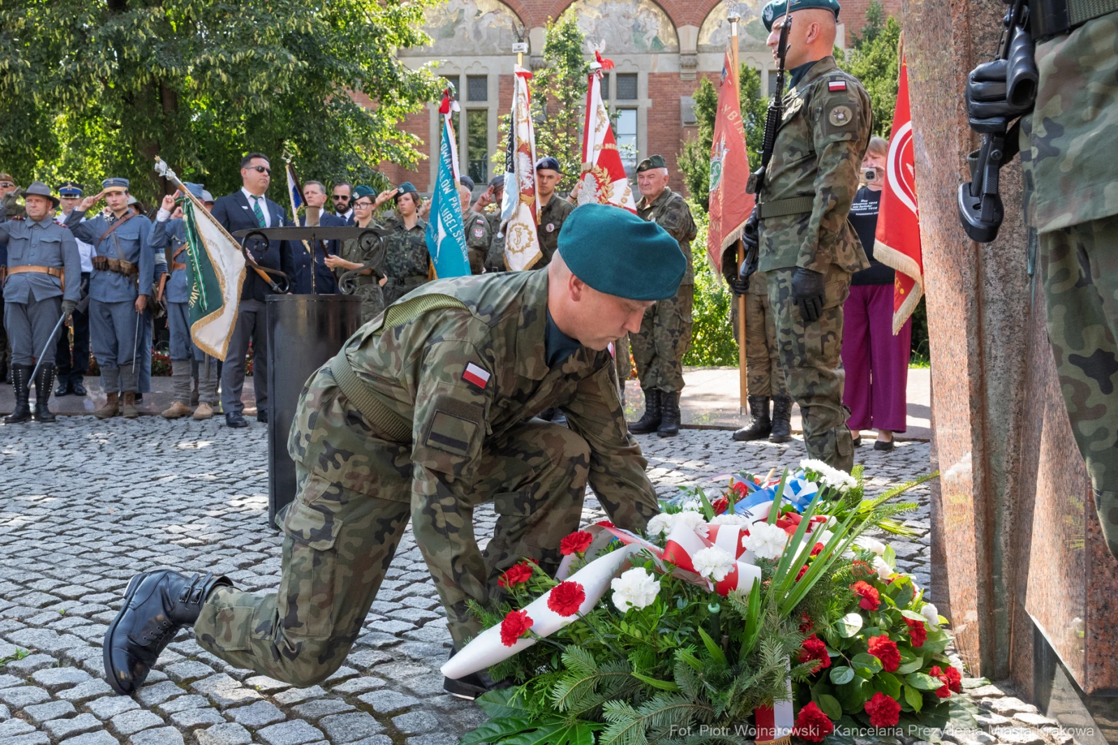 Żołnierz składa wieniec na grobie, w tle obecni uczestnicy ceremonii.  Autor: Piotr Wojnarowski