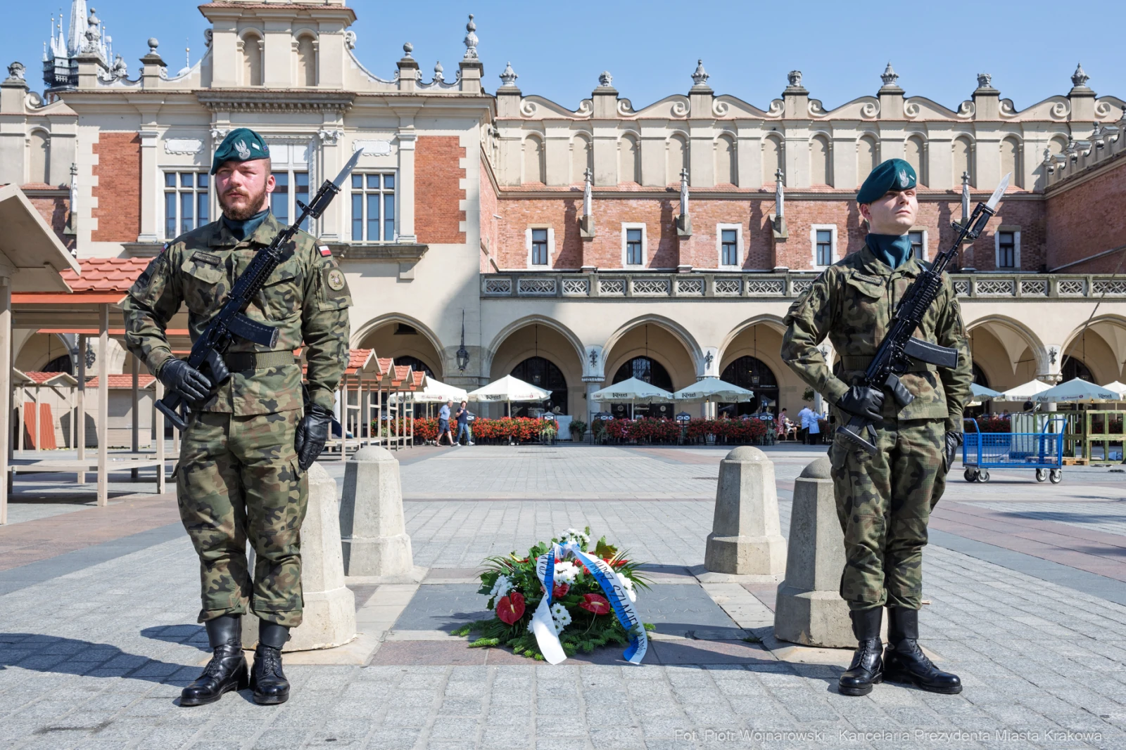 Dwóch żołnierzy w mundurach wojskowych stoi na placu, obok leży wieniec kwiatów.  Autor: Piotr Wojnarowski
