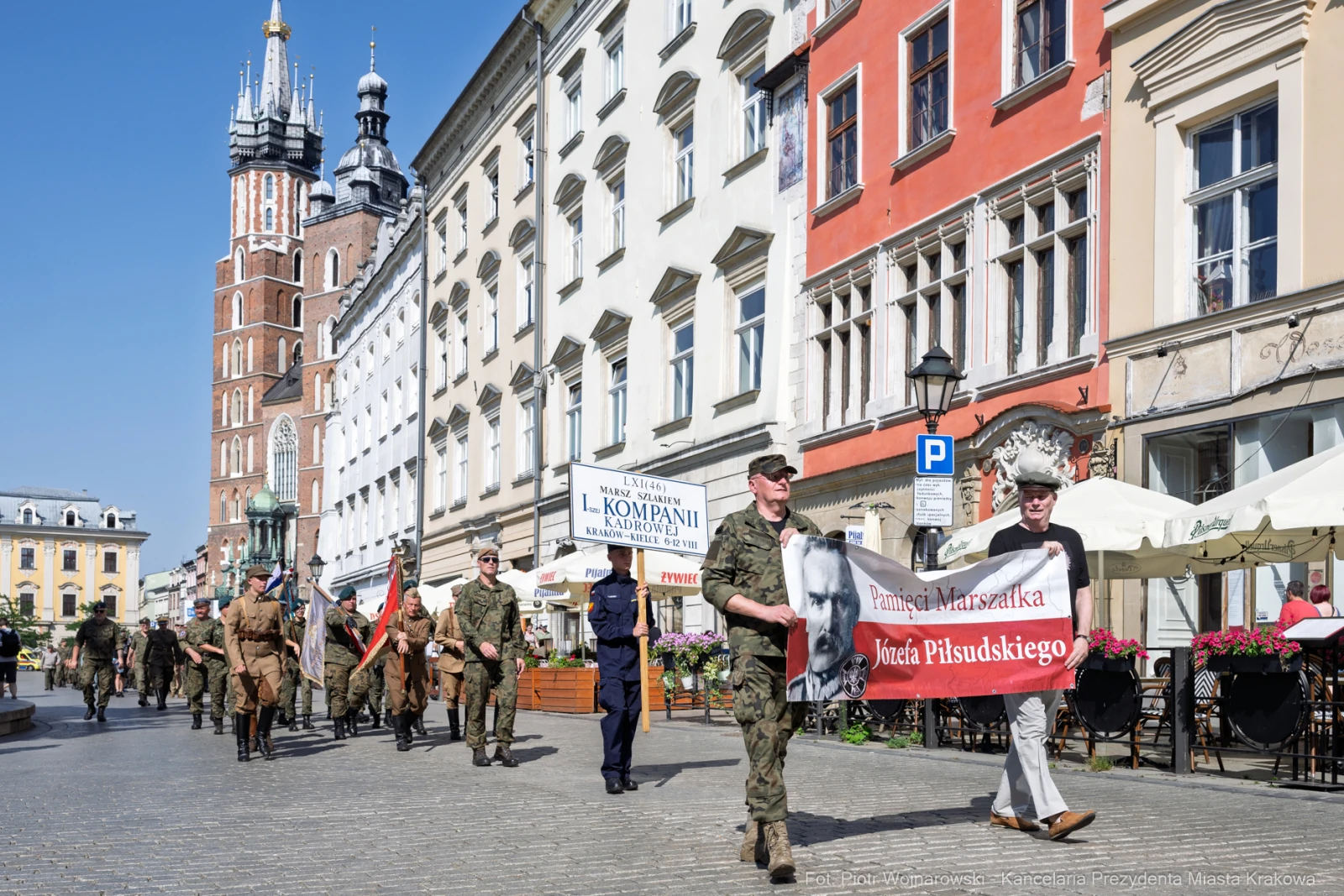 Marsz z flagami i transparentem upamiętniającym Józefa Piłsudskiego na krakowskim rynku.  Autor: Piotr Wojnarowski