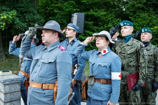 Żołnierze w mundurach historycznych składają honory podczas ceremonii.