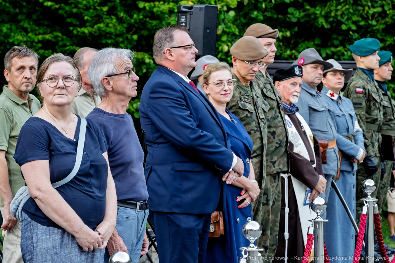 Grupa ludzi w różnych strojach, w tym mundurach wojskowych, podczas uroczystości.  Autor: Piotr Wojnarowski