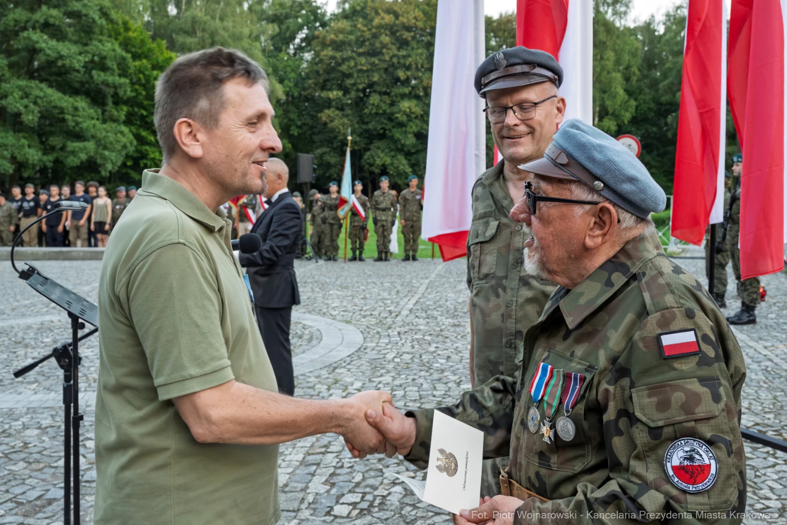 Uroczystość wręczenia odznaczeń wojskowych z udziałem żołnierzy i flag narodowych.  Autor: Piotr Wojnarowski