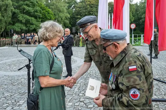 Wręczenie odznaczeń wojskowych podczas ceremonii z udziałem żołnierzy i cywilów.