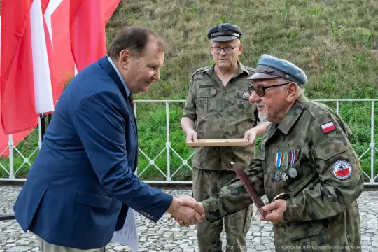 Uroczystość wręczenia odznaczeń w obecności weteranów i flagi Polski.