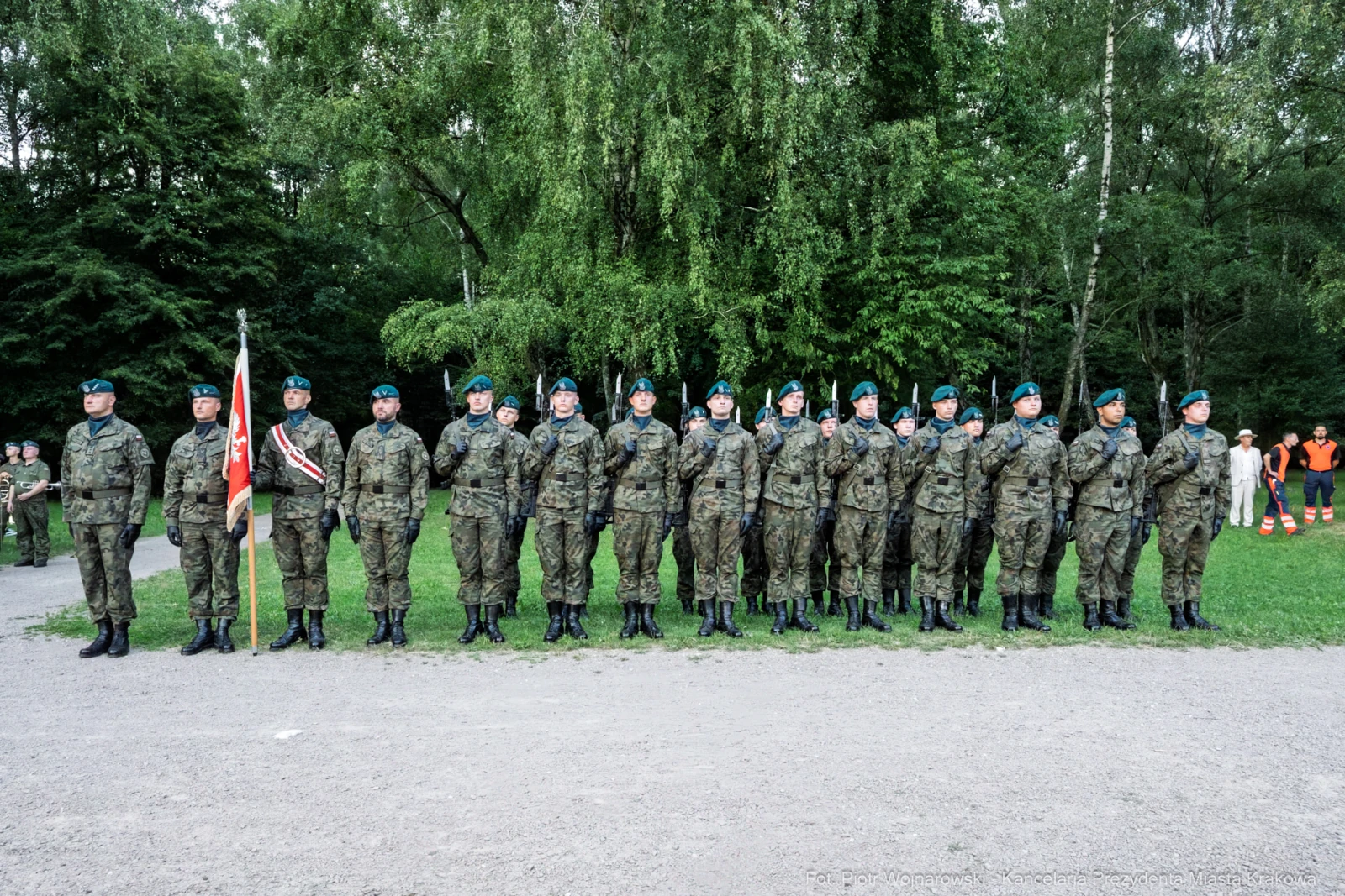 Żołnierze w mundurach wojskowych stoją w szeregu, trzymając flagę.  Autor: Piotr Wojnarowski