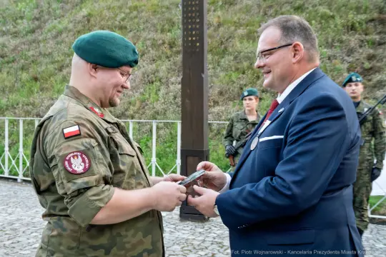 Wręczenie odznaczenia wojskowego przez oficera w mundurze cywilnemu przedstawicielowi.