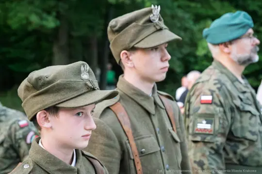 Młodzi mężczyźni w mundurach wojskowych podczas uroczystości.