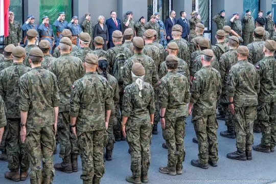 Ceremonia wojskowa z żołnierzami w mundurach i przedstawicielami władz.