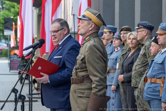 Uroczystość z okazji święta narodowego z mówcami i uczestnikami w mundurach.